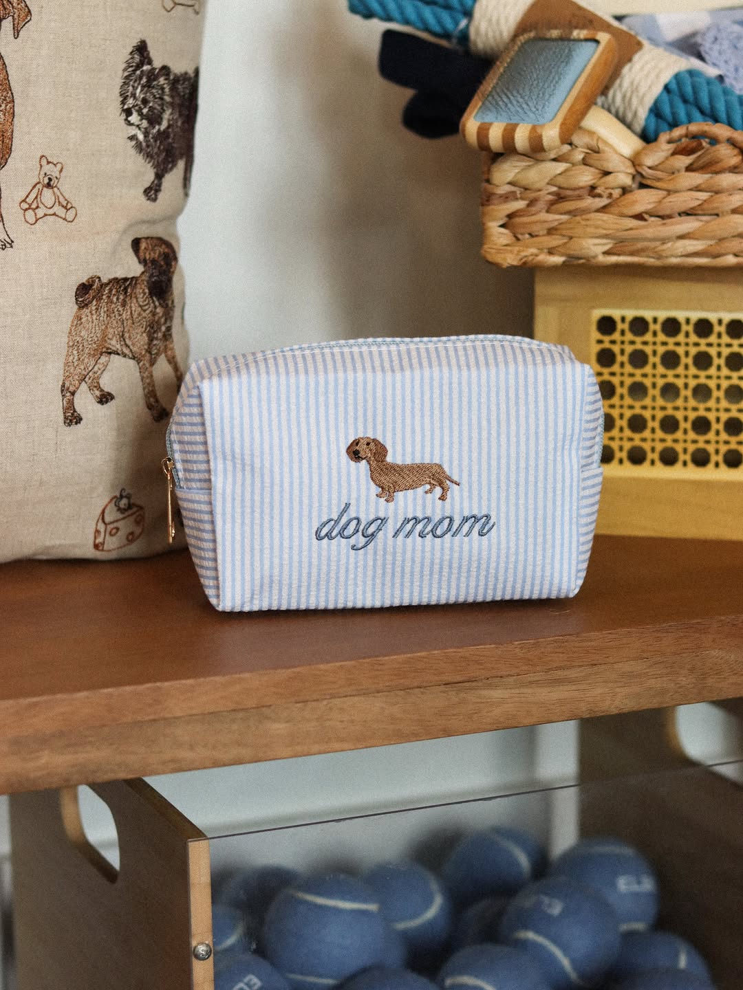 Embroidered dog mom pouches on a shelf in the shop